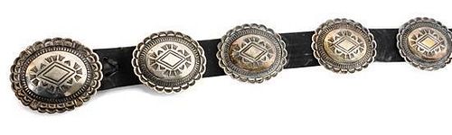A Navajo Silver Concho Belt Length of belt 38 inches; buckle 3 x 2 1/2 inches (approx.)