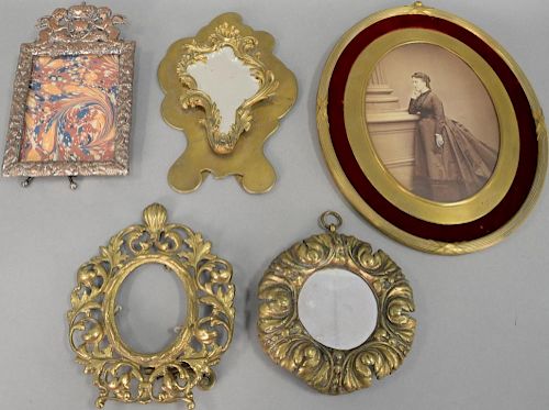 Five bronze and brass frames to include a large oval French frame and silverplated frame. 8" to 16 1/2"