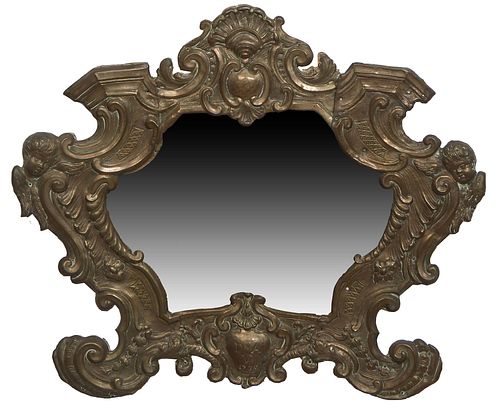 French Brass Repousse Mirror, 19th c., with a shell crest over a frieze with winged putti corners, to scrolled legs and a central medallion inscribed 