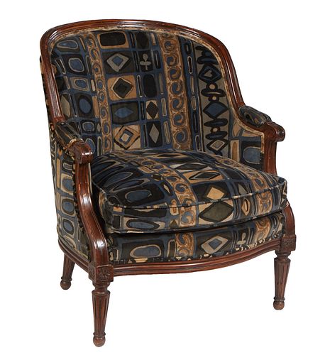 French Louis XVI Style Carved Walnut Bergere, 20th c., the curved upholstered back to upholstered arms and a bowed removable cushion seat, on turned t