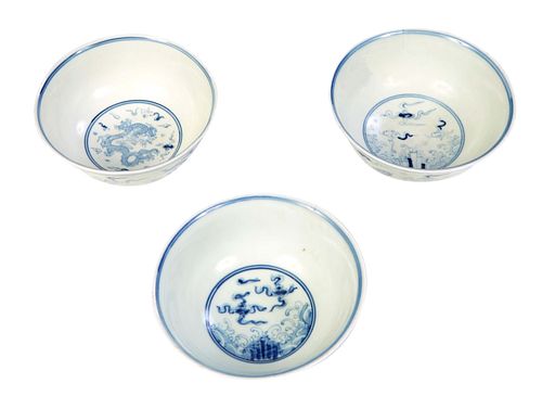 Three Chinese Blue and White Porcelain Bowls, 20th c., one with a dragon decorated interior, the other two with cloud and wave decoration, each with a