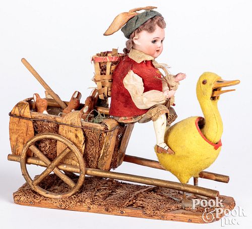 Bisque head doll riding a duck cart