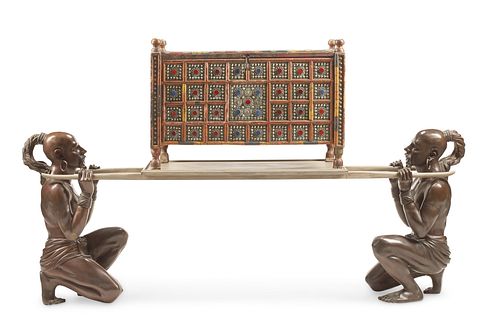 A carved wood chest with bronze figural supports
