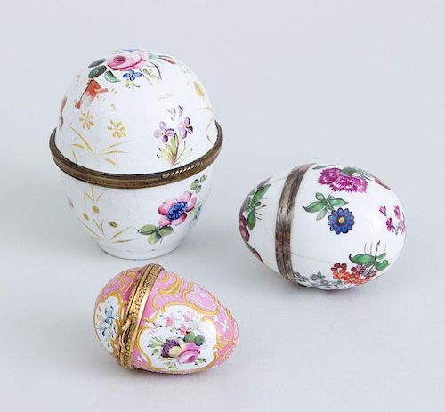 TWO SOUTH STAFFORDSHIRE ENAMEL EGG-FORM BOXES AND A PORCELAIN EGG-FORM BOX