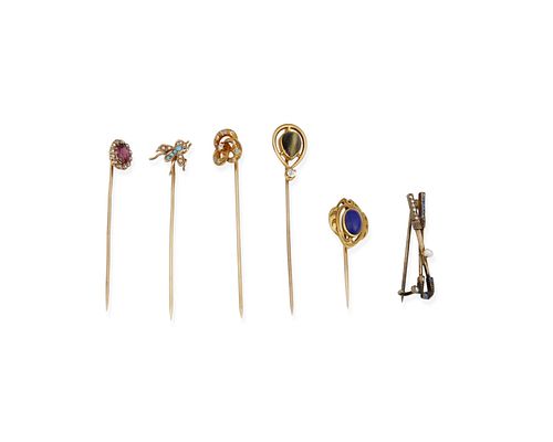 A group of five stick pins and one golf pin