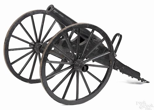 Cast iron cannon with a 1 1/4'' bore, mounted to a painted wood carriage with wood spoke wheels,