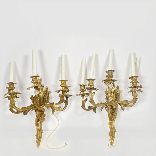 Pair Rococo Gilt Bronze Sconces, Each with a scrolled acanthus back plate issuing five scrolled candlearms with floral bobeches17in. (43cm) h. 18in. (