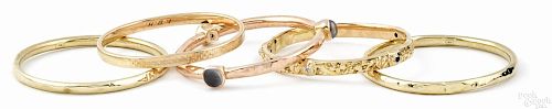 Four 14K yellow gold bangle bracelets, together with a 14K rose gold bracelet, 29.8 dwt.