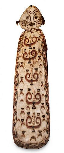 * A Carved Wooden Ceremonial War Shield, Papua, New Guinea Height 86 inches