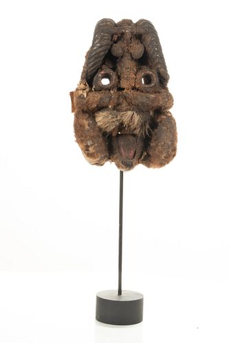 African Carved Wood, Fiber And Animal Fur  Mask On Black Stand.