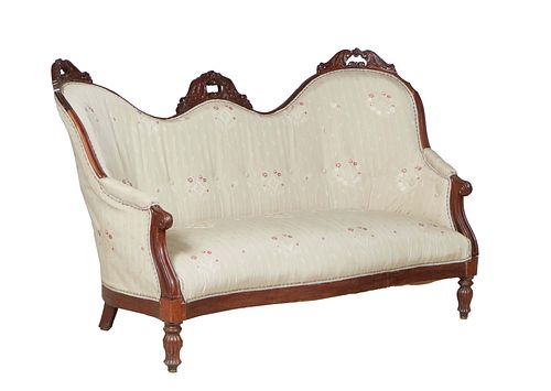 French Louis Philippe Style Carved Walnut Settee, late 19th c., the serpentine crest rail with three floral carved crests over an upholstered back, up