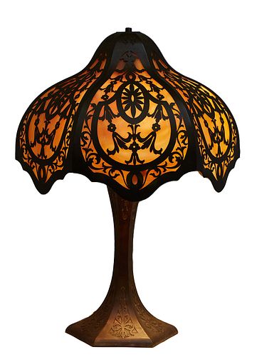 Unusual American Art Nouveau Patinated Spelter Table Lamp, c. 1920, the bulbous circular brass floral cutout shade with caramel slag glass panels, one