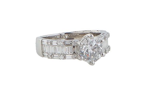 Lady's 18K White Gold Dinner Ring, with a 1.5 carat round diamond on a tapering band with baguette diamond shoulders within borders of baguette and ro