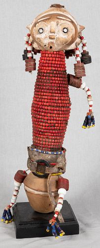 AFRICAN WOOD, DOLL, RED BEADS, FABRIC,  LEATHER, PIGMENT AND METAL WITH GROMMET EYES, H 16", W 6", D 2.5" 