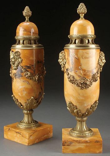 A PAIR OF FRENCH GILT BRONZE MOUNTED MARBLE URNS