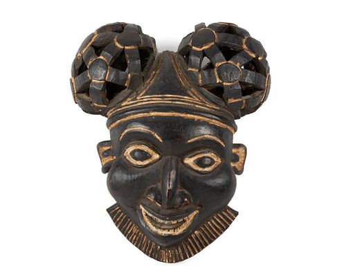 A Cameroonian carved wood helmet mask