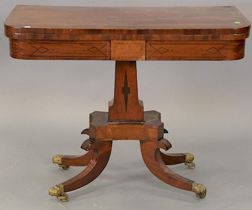 George III mahogany game table having banded and brass inlaid top, felt interior on base with down swept members. ht. 28in.,