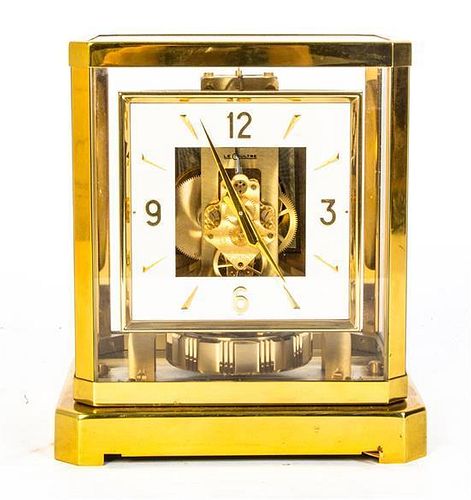 * A Swiss Brass and Glass Atmos Clock, Height 9 inches.