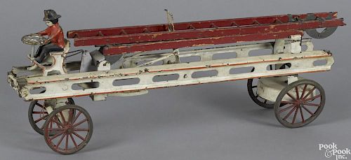 Kingsbury painted tin clockwork fire ladder truck with rubber wheels and a cast iron driver