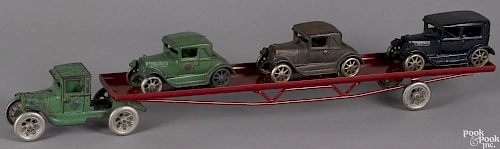Arcade cast iron flatbed car carrier with three cars and a reproduction trailer, 24 1/2'' l.