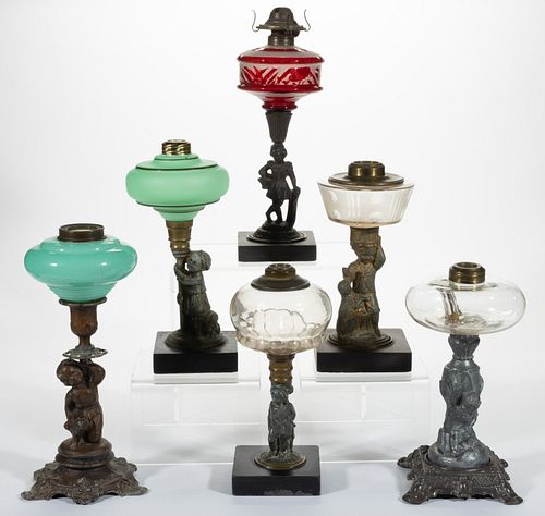 ASSORTED FIGURAL STEM GLASS AND METAL KEROSENE STAND LAMPS, LOT OF SIX,
