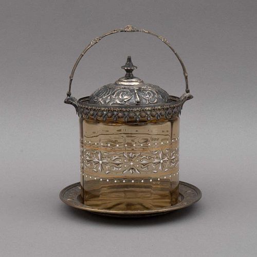 HIELERA. Ca. 1900. Elaborada en vidrio color ámbar, con aplicaciones de metal dorado. Decoraciones orgánicas. Detalles de conservación