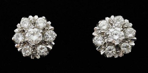 A pair of diamond cluster earrings, each set with seven round brilliant cut diamonds in a claw setting. Mounted in 18ct gold.