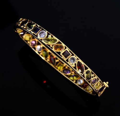 Multi gem hinged bangle, set with peridot, citrine, garnet, ruby, sapphire and other stones.  Mounted in 18 ct yellow gold.