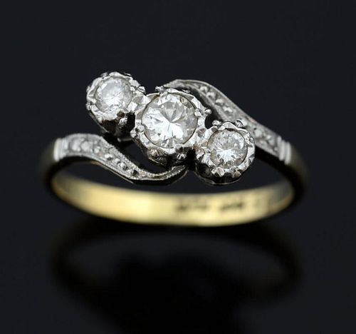 Three stone diamond crossover ring, set with round brilliant cut diamonds in an illusion platinum setting to a plain 18 ct go