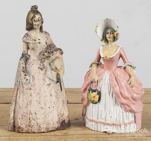 Two cast iron women doorstops, ca. 1900, 11 1/2'' h., and 10 1/2'' h.