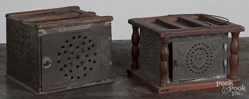 Two punched tin foot warmers, late 19th c., one with heart decoration, 5 3/4'' h. and 6 1/4'' h., together with a brass bucke