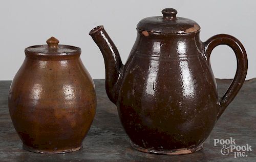 Redware teapot, 19th c., 9 1/4'' h., together with a lidded crock, 7 1/4'' h. Provenance: Titus Geesey