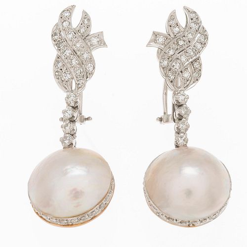 Par de aretes con medias perlas y diamantes en oro blanco 12k. 2 medias perlas cultivadas en color blanco de 13 mm. 44 diamantes...