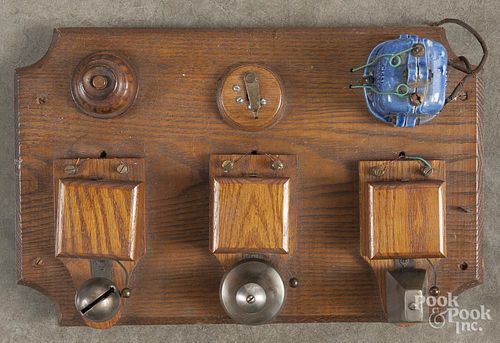 Three-alarm bells, ca. 1900, mounted to a display board, 17'' w.