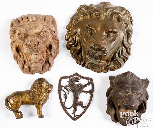 Five metal and pressboard lion plaques