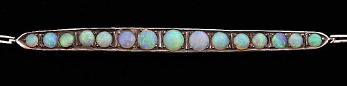 Early 20th C Opal line bracelet set with graduated round cabochon cut opals, mounted in white metal tested as 9ct gold.