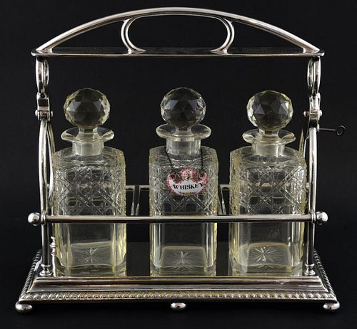 Silver plated three decanter tantalus with gadrooned border, on bun feet.