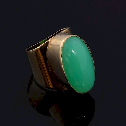 1970's gold and chalcedony dress ring set with oval cabochon chalcedony to the centre to a wide gold band in 9 ct gold.