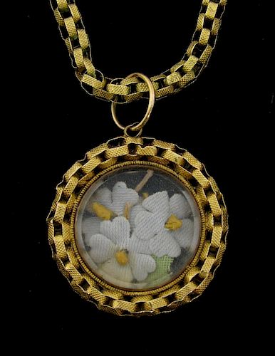 Victorian gold locket and chain, the locket containing fabric flowers.