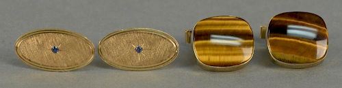 Two pairs of 14K cufflinks, one pair set with tiger-eye and signed Karram, the other set with small blue sapphire.