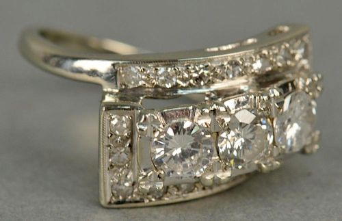 14K ladies ring set with three round diamonds surrounded by 18 small diamonds, three large stones total weight 1.65cts.