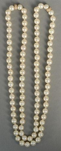 Pearl necklace mounted with two gold and diamond rondels, 8mm. 
lg. 34in.