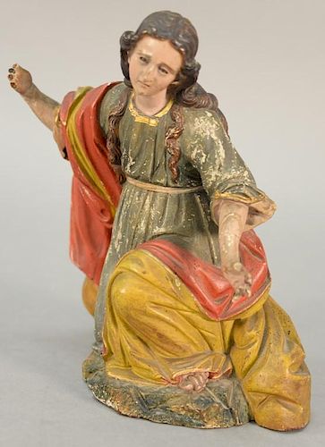 Carved and polychrome painted wood creche figure of Mary with glass eyes wearing gilt decorated red, yellow, and green robes.