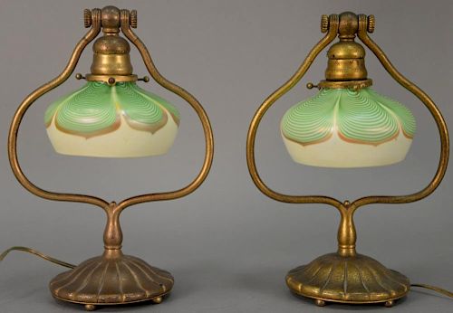 Pair of Tiffany Studios bronze piano lamps with pulled feather art glass shades and harp form base with swinging socket raise