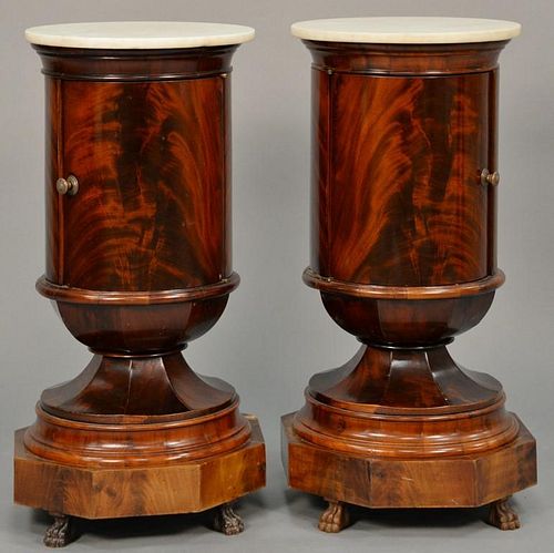 Pair of Empire round mahogany stands having marble tops over one door over octogon base resting on claw feet.  ht. 31 1/2in.,