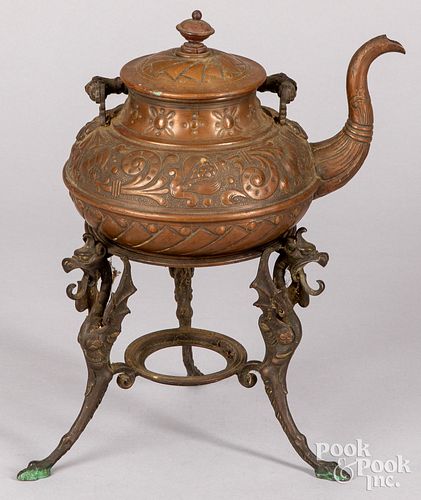Embossed copper tea kettle on a bronze stand