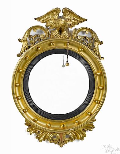 Giltwood convex mirror, ca. 1800, with an eagle crest, 34'' h.