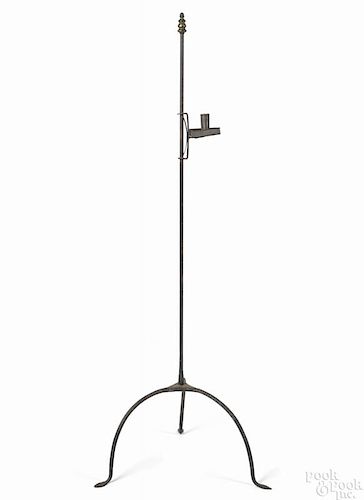 Wrought iron floor standing candlestand, 19th c., with an adjustable tin candlecup, 49'' h.
