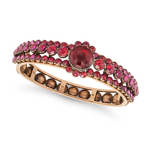AN ANTIQUE FRENCH PERPIGNAN GARNET BANGLE in 18ct rose gold, set throughout with rose cut foiled ...