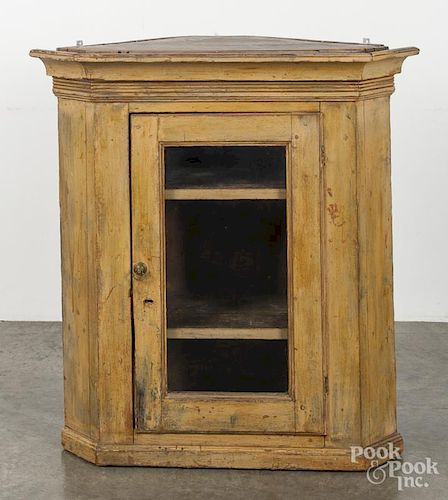 Painted hard pine hanging corner cupboard, early 19th c., retaining a mustard surface, 39'' h.